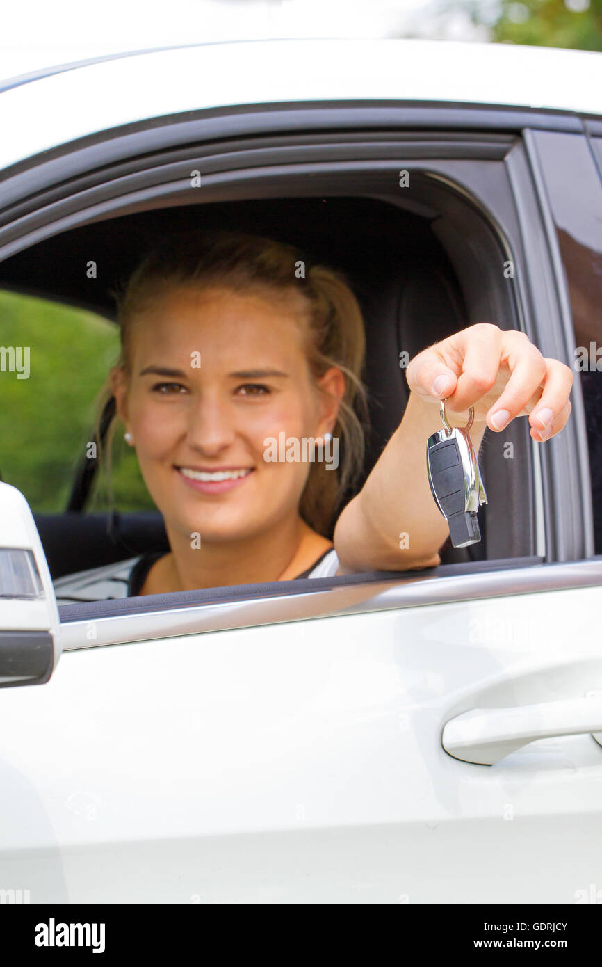 Jeune femme tenant la clé de sa nouvelle voiture Banque D'Images