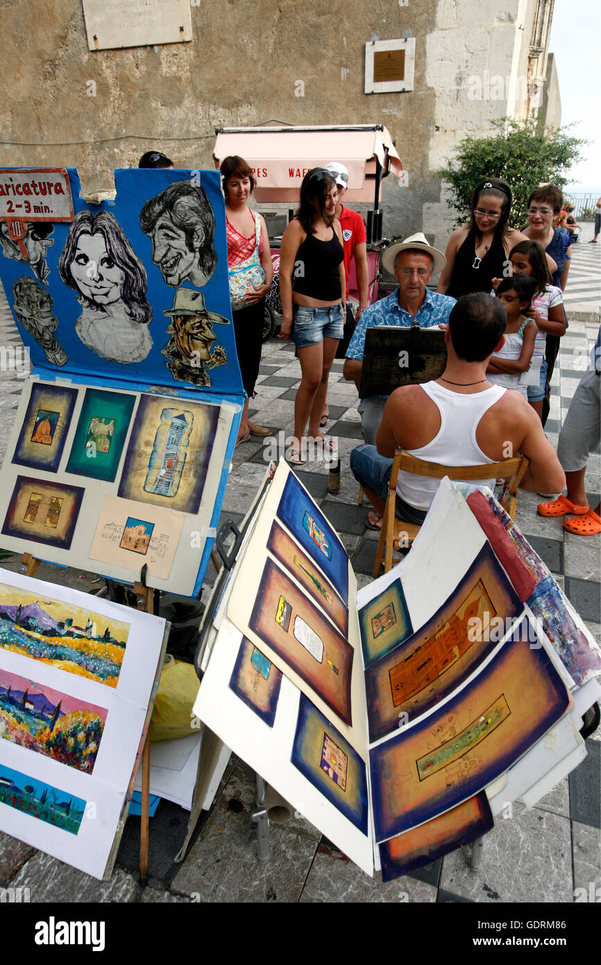 Un peintre dans la vieille ville de Taormina en Sicile en Italie du sud en Europe. Banque D'Images