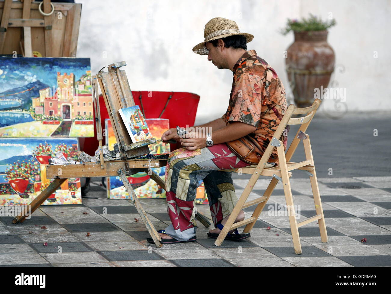 Un peintre dans la vieille ville de Taormina en Sicile en Italie du sud en Europe. Banque D'Images