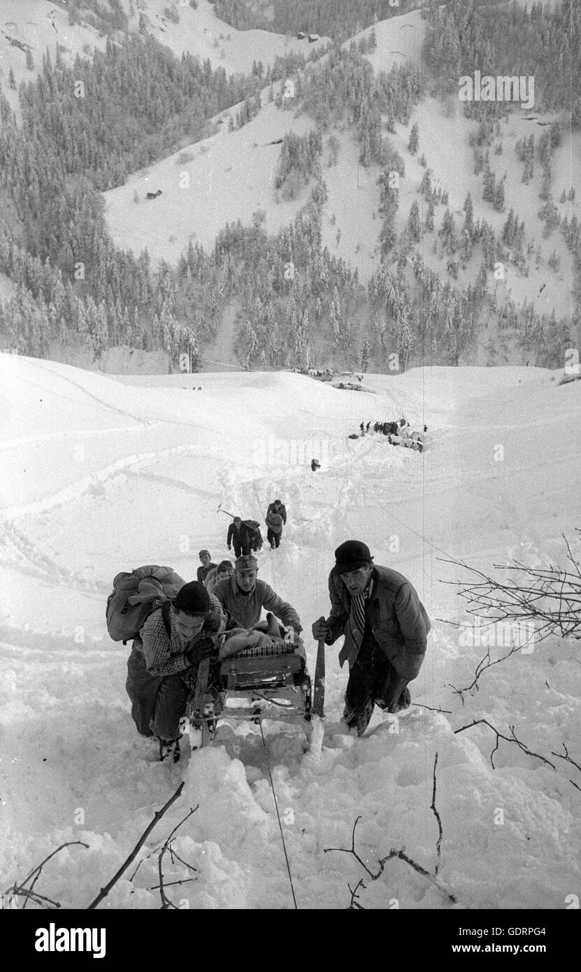 L'équipe de sauvetage transportant une personne sauvée après les avalanches à Blons, 1954 Banque D'Images