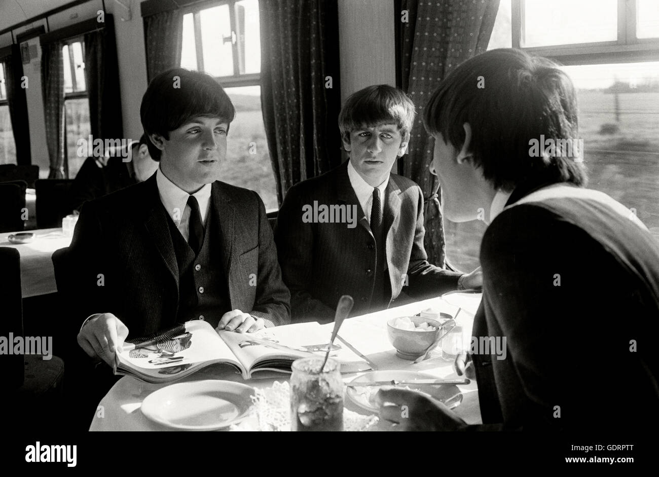 Paul McCartney, Ringo Starr et Georg Harrison dans la voiture-restaurant sur une dure journée de train de nuit. Banque D'Images