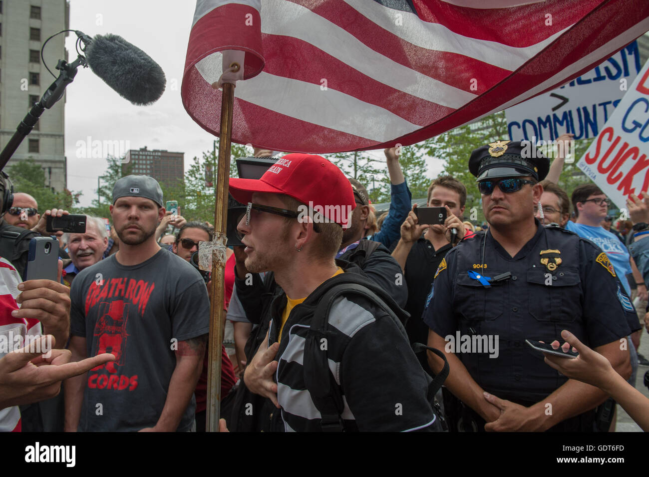 Cleveland, Ohio, USA. 21 juillet, 2016. Partisan de l'Atout, centre est remis en question par un anti-Trump manifestant, à gauche comme la police et les médias, juste devant la Convention nationale du parti républicain à Cleveland. Credit : Bryan Smith/ZUMA/Alamy Fil Live News Banque D'Images