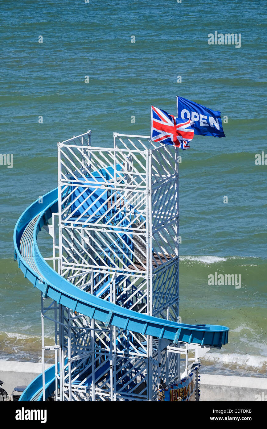 Une 'Union Jack' et 'Ouvrir' flag flying ensemble au sommet d'un Helter Skelter ride à Cromer à Norfolk Banque D'Images