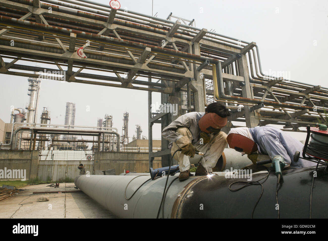 2 travailleurs chinois weild tuyau à l'usine pétrochimique de Shanghai Shanghai, Chine Le jeudi, Août 29, 2006. Banque D'Images