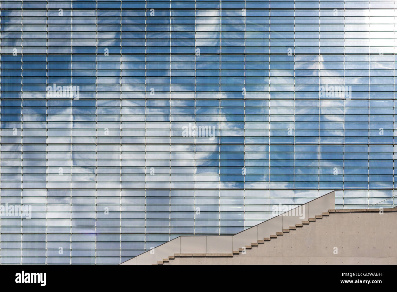 Soleil, ciel bleu et nuages reflet dans un bâtiment moderne à la façade de verre Banque D'Images