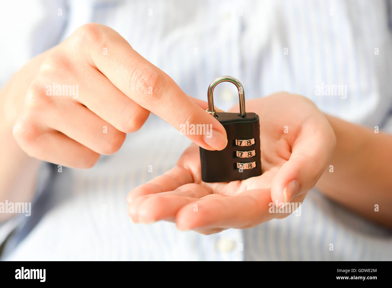 Business Woman holding un verrouillage de chiffrement dans ses mains, ce qui suggère l'assurance-vie ou de la sécurité personnelle Banque D'Images