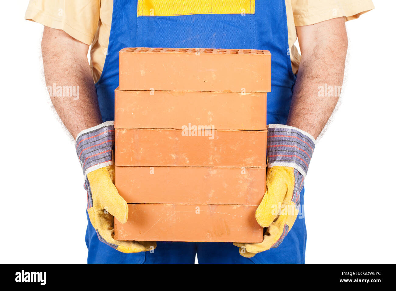 Travailleur en vêtements de travail et des gants détient quelques briques dans ses mains. Banque D'Images