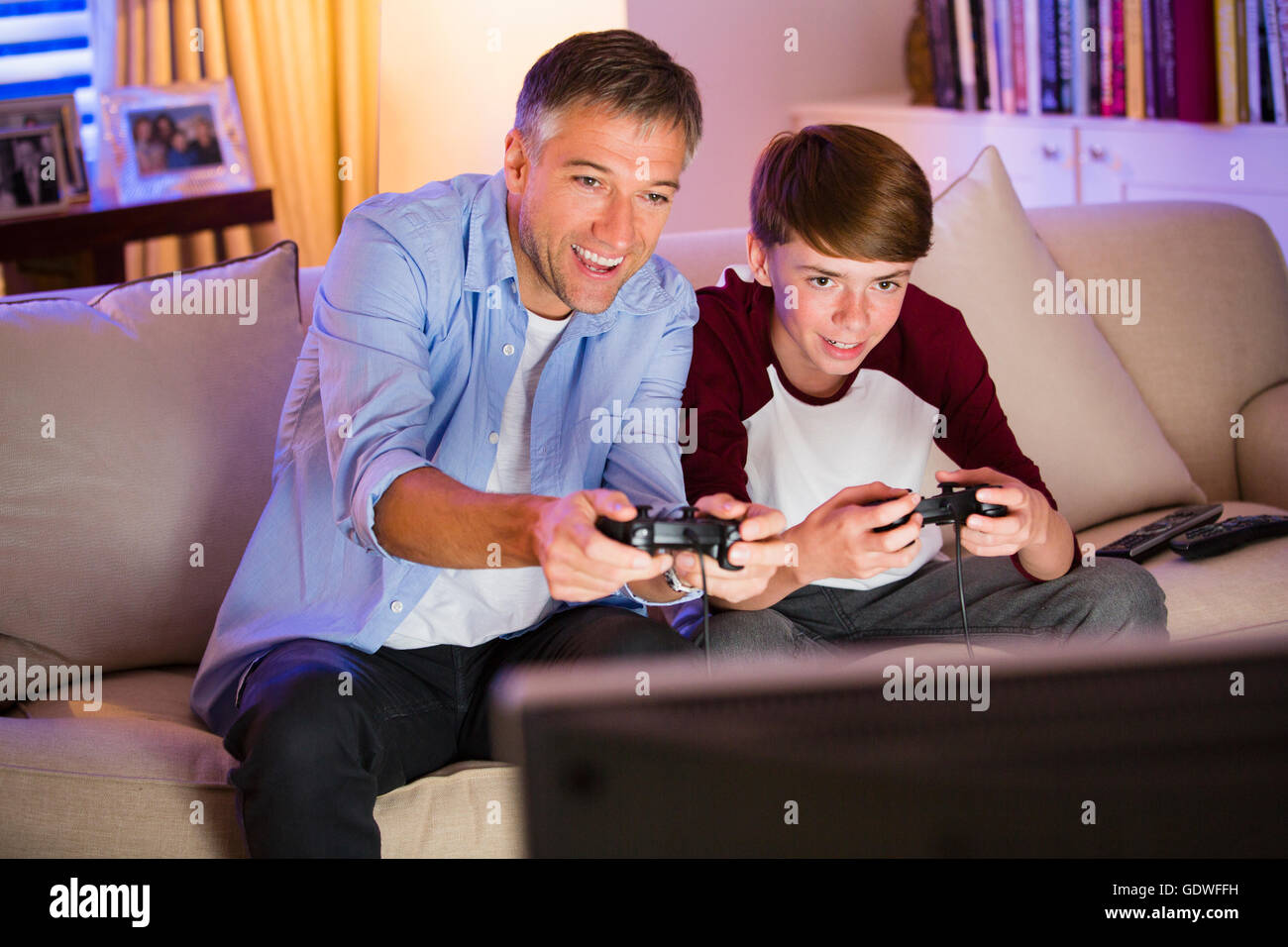Father and Son playing video game in living room Banque D'Images