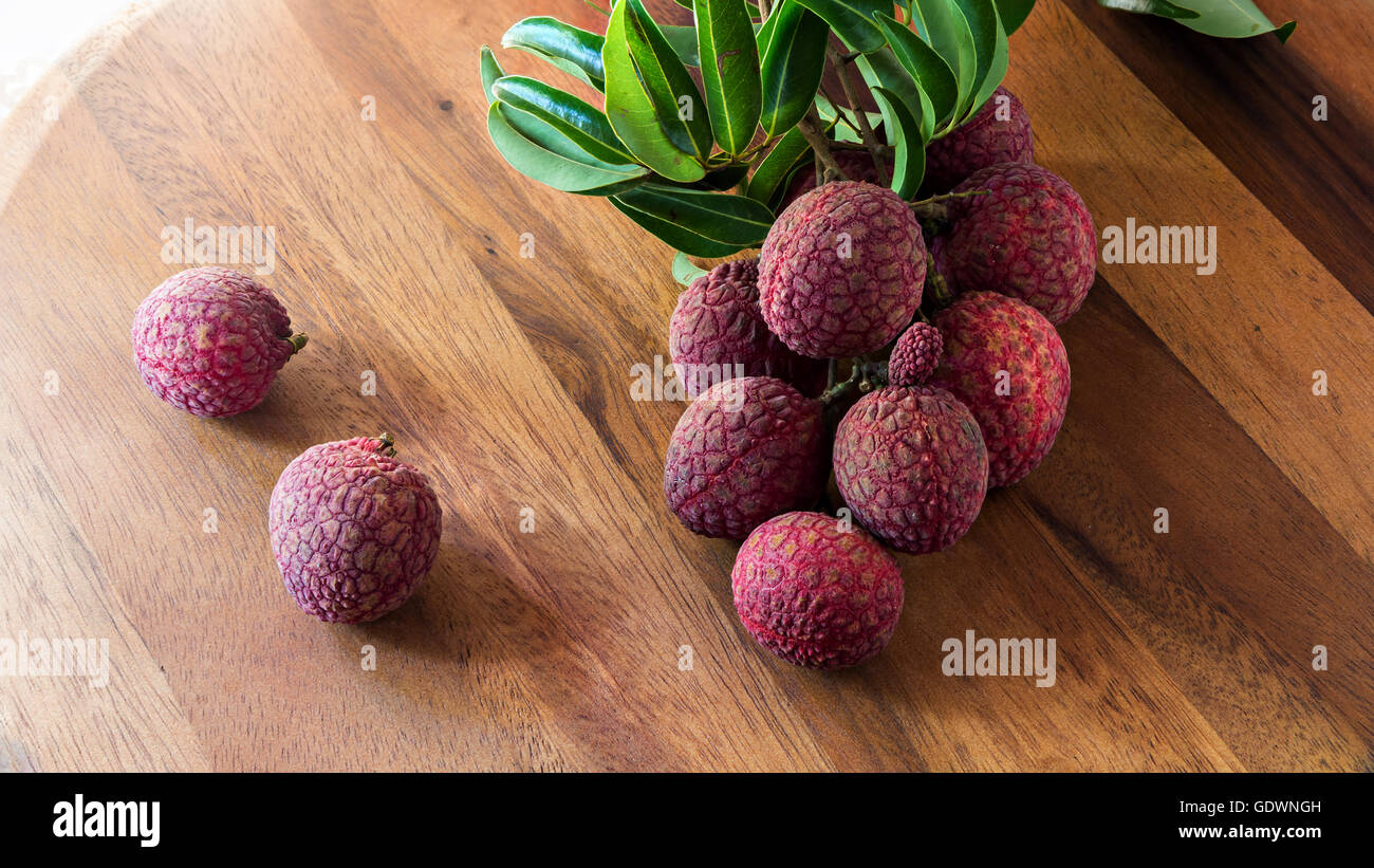 Le litchi avec des feuilles sur une planche en bois, still life Banque D'Images