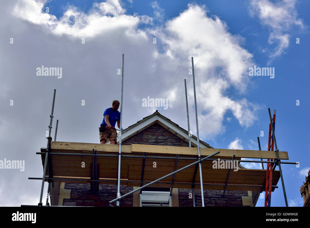 Pignon de toit avec apex et échafaudages scaffolder en silhouette, UK Banque D'Images