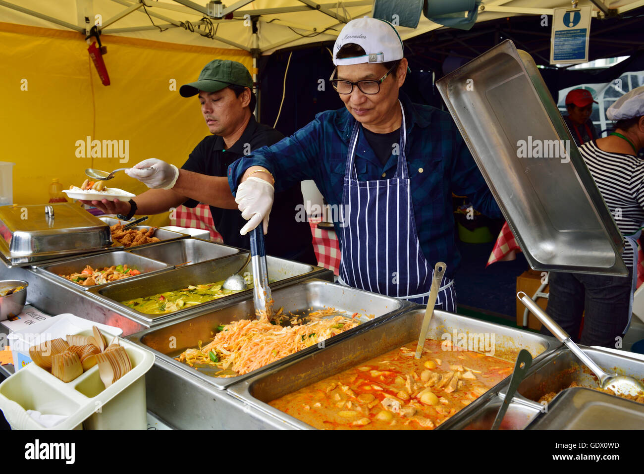 Préparer et servir la nourriture asiatique en chapiteau chapiteau au festival, UK Banque D'Images