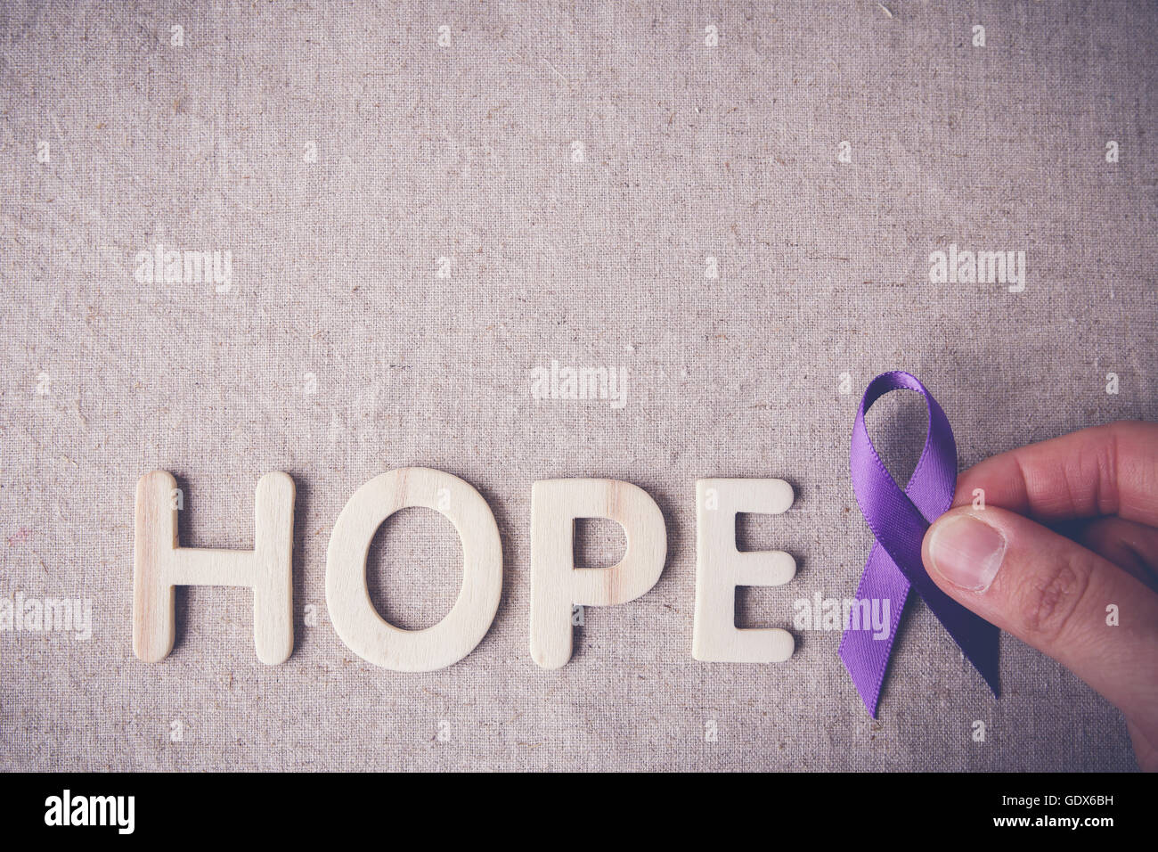 Tenir les doigts ruban violet avec espoir, tonifiant, lettre en bois de la maladie d'Alzheimer, cancer du pancréas, sensibilisation à l'épilepsie, Hodgk Banque D'Images