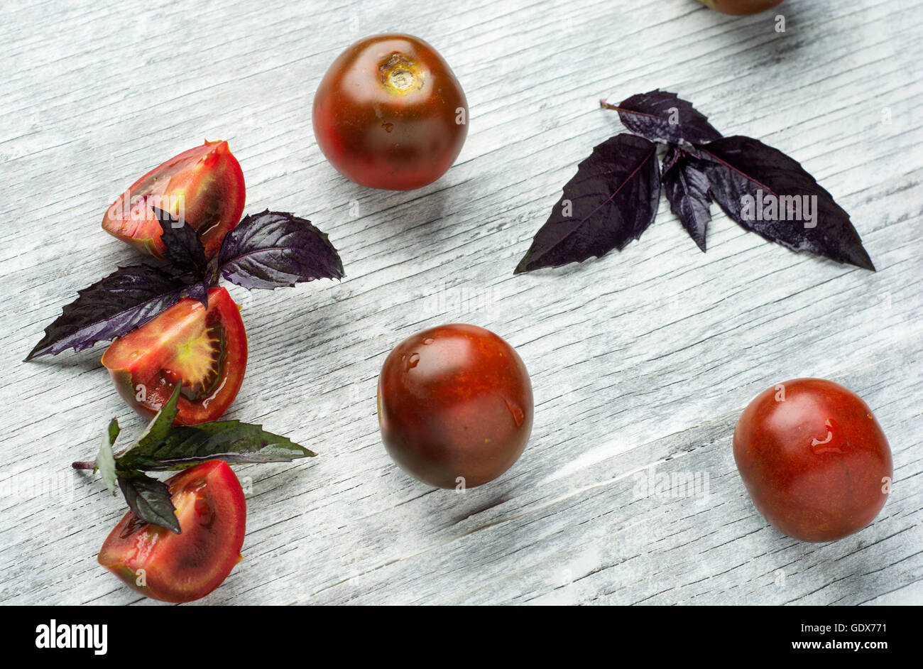 Les tomates au basilic sur fond de table en bois. La composition des produits alimentaires. Vue d'en haut Banque D'Images