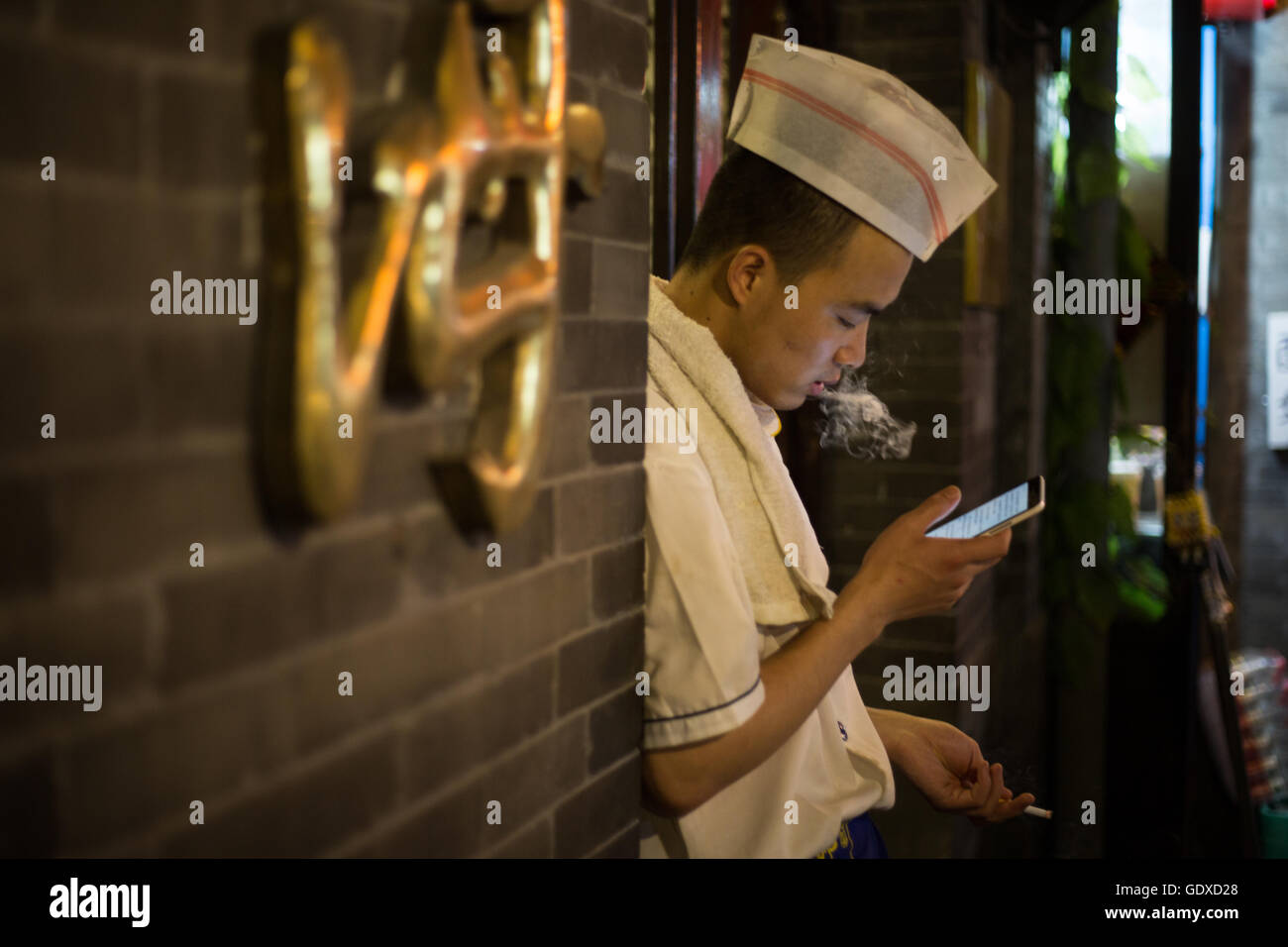 Les jeunes Chinois jouent avec leurs smartphones et les médias sociaux, à Beijing, Chine Banque D'Images