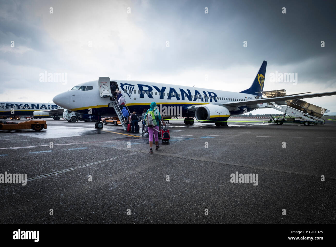 Les passagers d'un vol Ryanair sous la pluie à l'aéroport Galileo Galilei de Pise, Toscane, Italie Banque D'Images