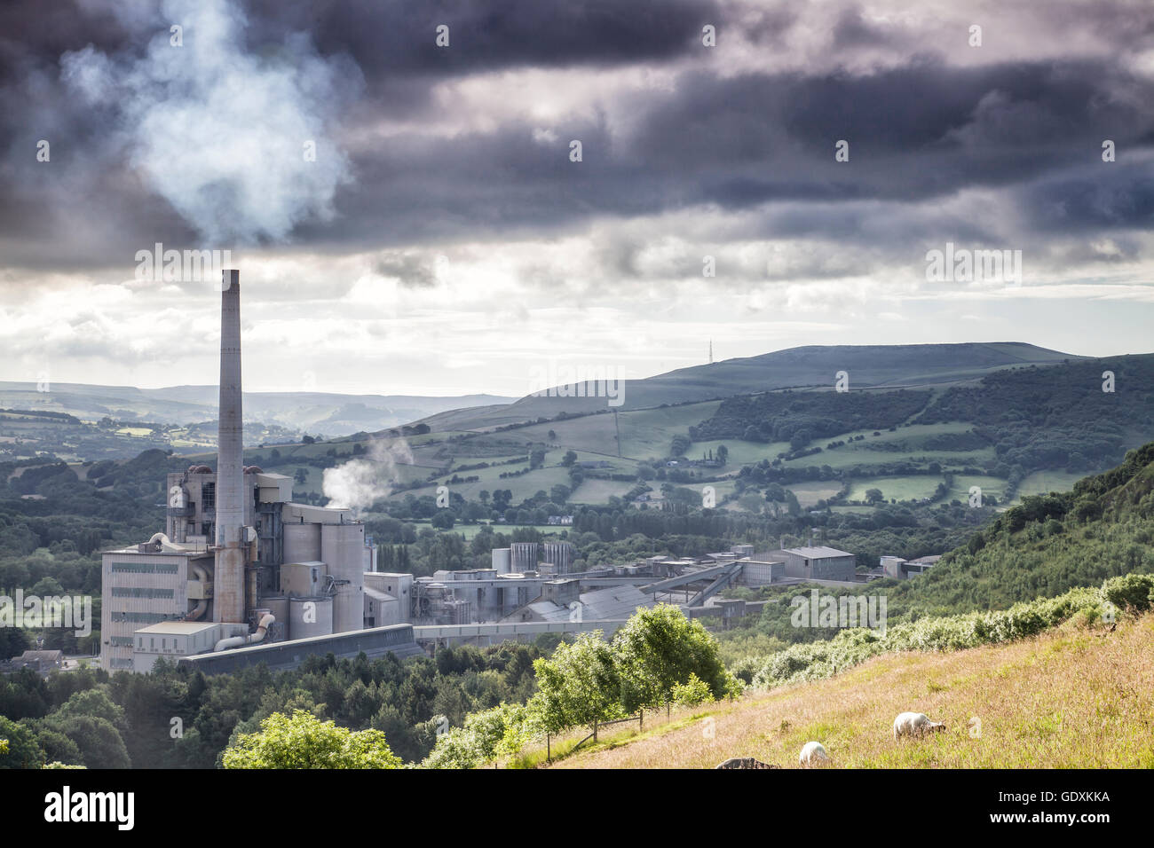 Cimenterie Lafarge,espère Valley, parc national de Peak District Derbyshire Smokey Cheminée en moody ciel nuageux. Campagne vallonnée Banque D'Images