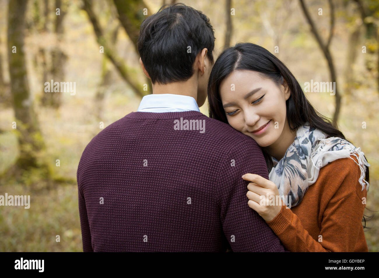 Portrait of young smiling woman hugging un homme avec les yeux fermés Banque D'Images