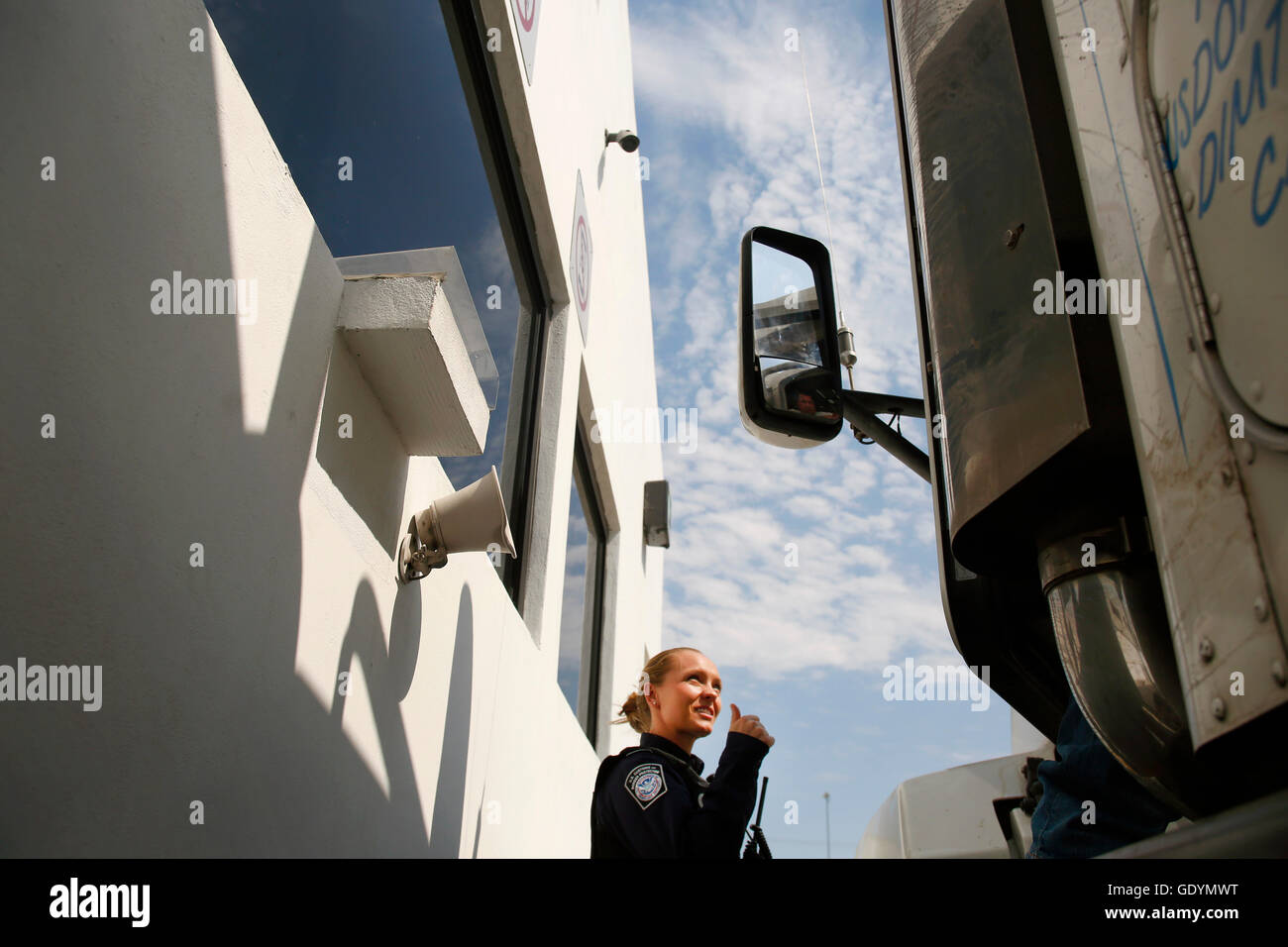 Le 22 juin 2016, un agent des douanes et de la protection des frontières des États-Unis envoie un signal d'approbation à un chauffeur de camion à l'installation d'inspection préalable du fret du côté mexicain du point d'entrée d'Otay Mesa, en Californie. L'installation fait partie du programme du CBP visant à accélérer les importations du Mexique vers les États-Unis Banque D'Images