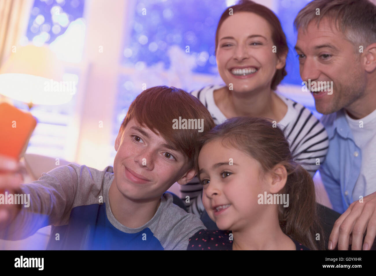Smiling family en tenant avec selfies téléphone appareil photo Banque D'Images