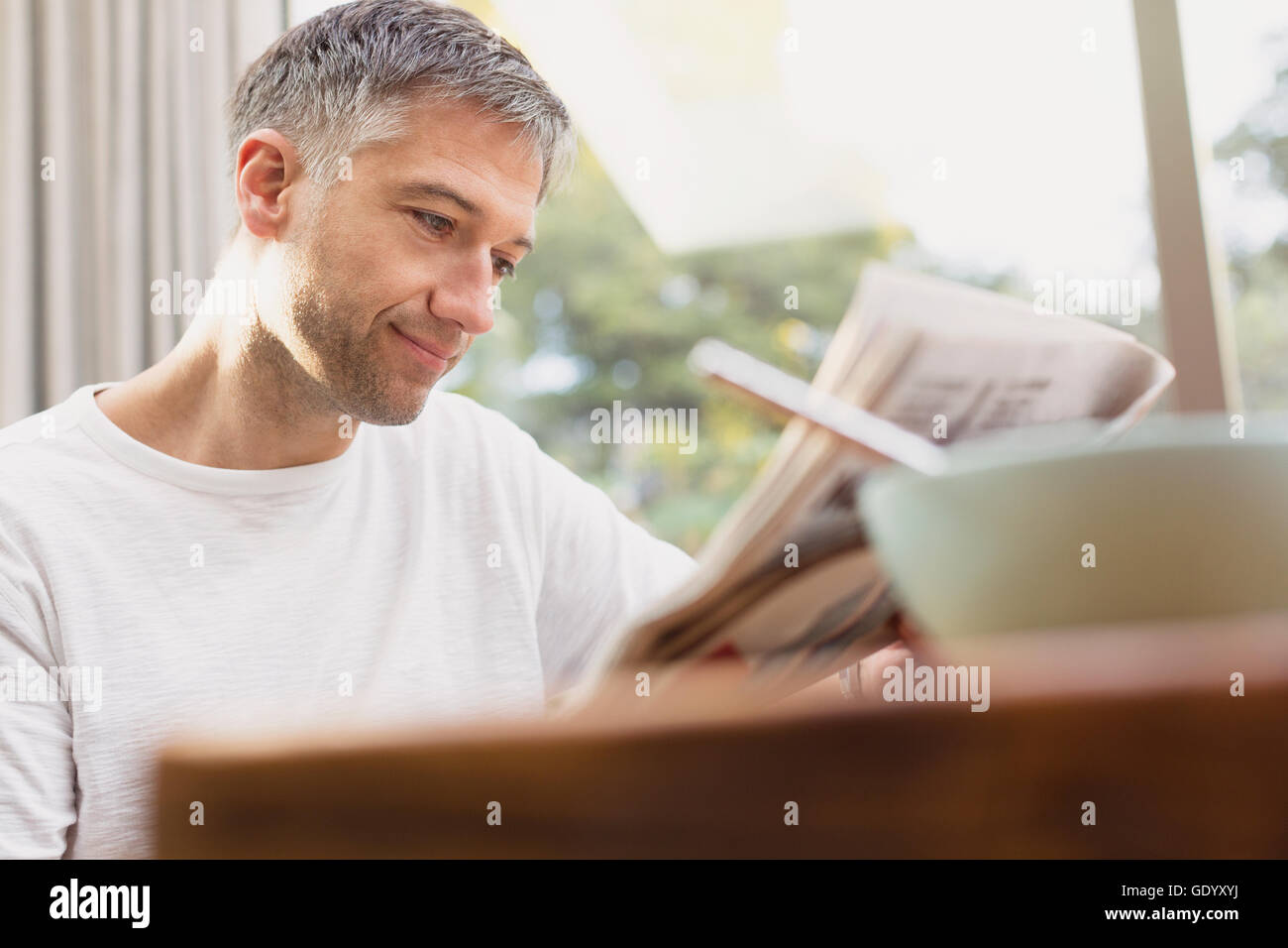 Man reading journal au petit déjeuner Banque D'Images