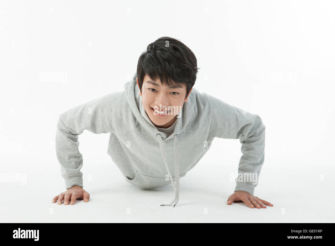 Smiling adolescent boy doing pushups Banque D'Images