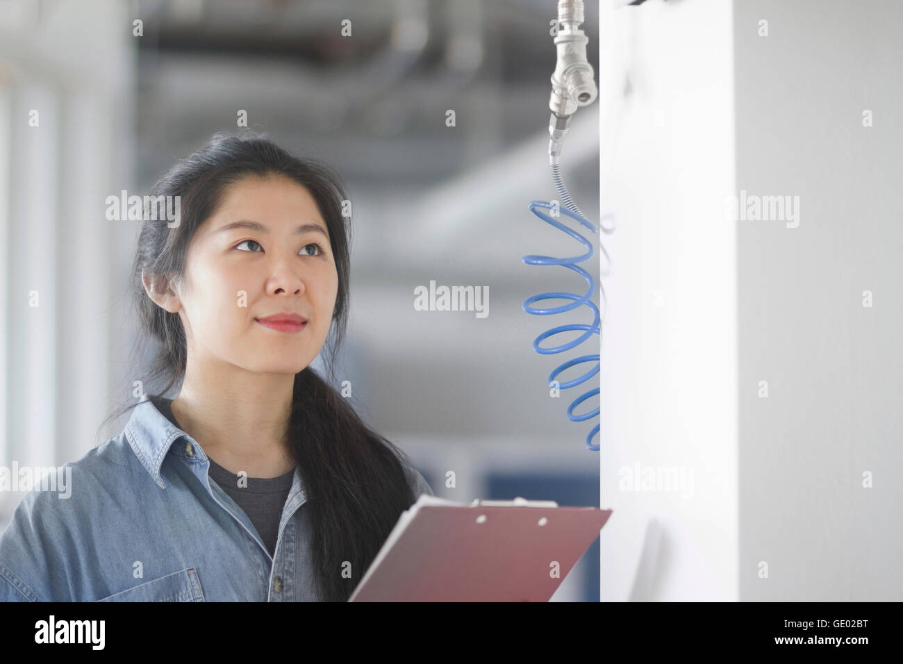 Jeune femme ingénieur travaillant dans une usine industrielle, Freiburg im Breisgau, Bade-Wurtemberg, Allemagne Banque D'Images