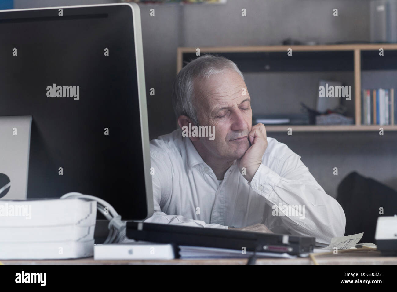 Senior businessman assis au bureau et chambre, Freiburg im Breisgau, Bade-Wurtemberg, Allemagne Banque D'Images