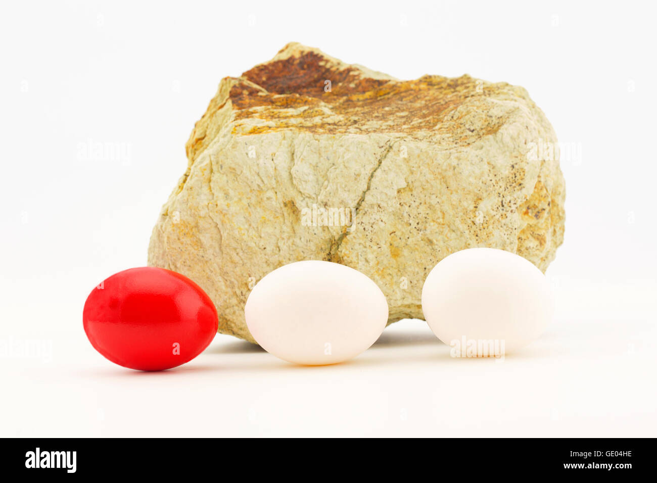 Problèmes d'investissement reflète dans l'oeuf rouge placé avec des œufs ordinaires dans les rochers, les temps difficiles. Banque D'Images