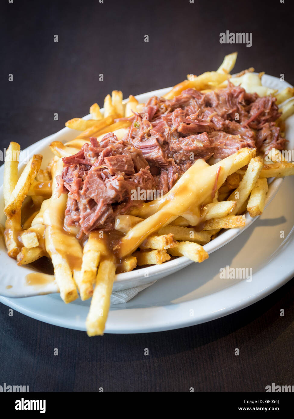 Un copieux plat de poutine de poitrine de boeuf de diner en milieu urbain à Edmonton, Alberta, Canada. Banque D'Images