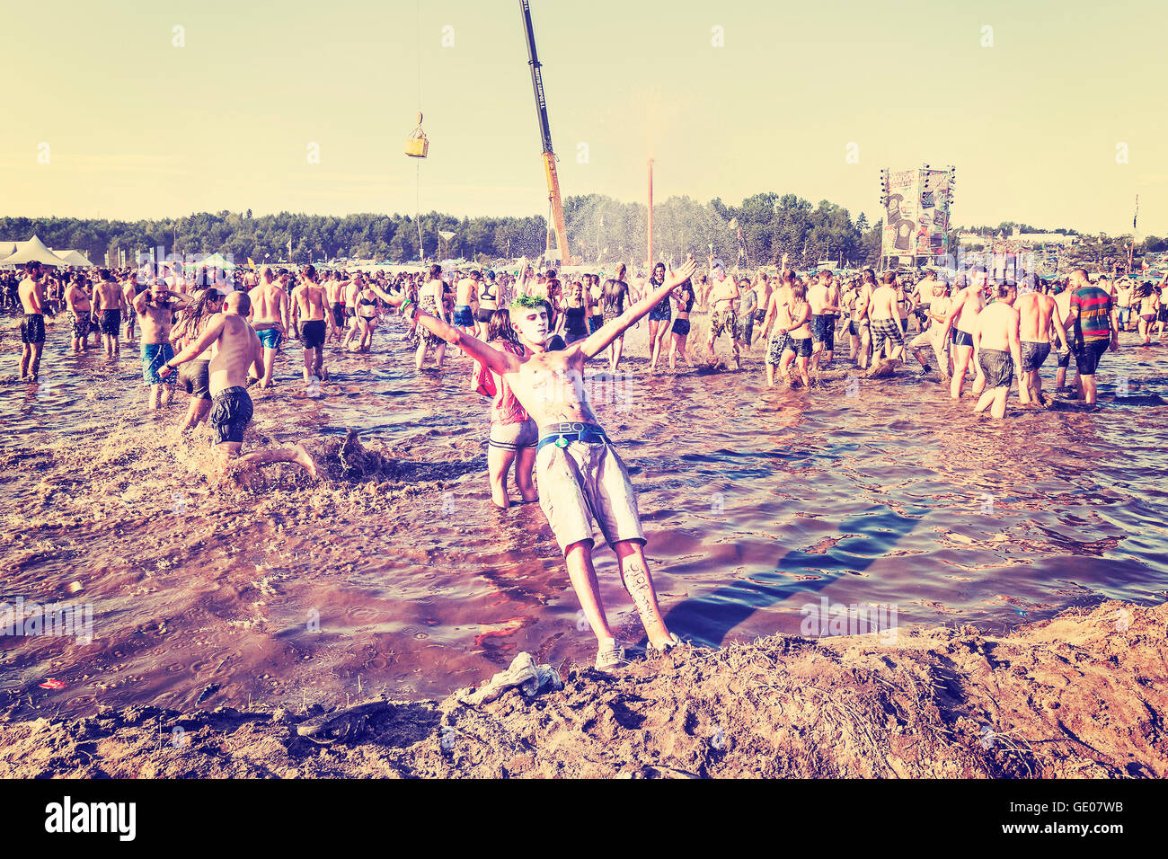 Jeune homme sauter dans la boue au cours du Festival de Woodstock 21 Pologne Willa Arte (Woodstock). Banque D'Images