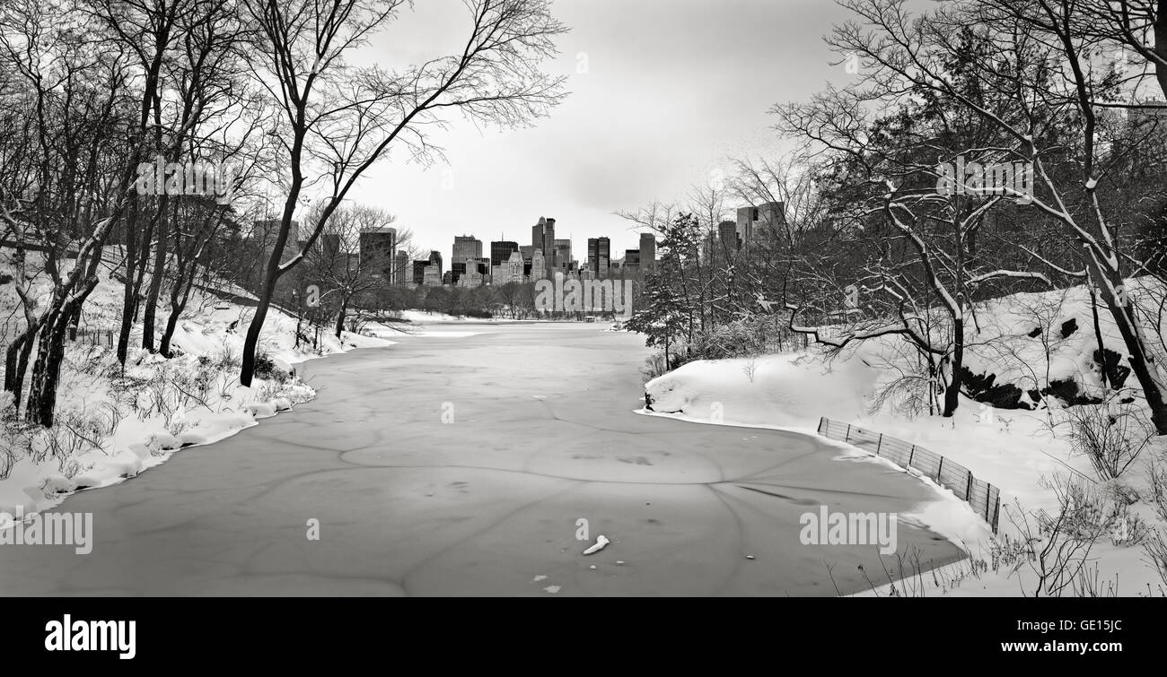Le lac gelé dans Central Park, avec Midtown gratte-ciel. Une paisible ville de New York en noir & blanc en hiver vue panoramique Banque D'Images