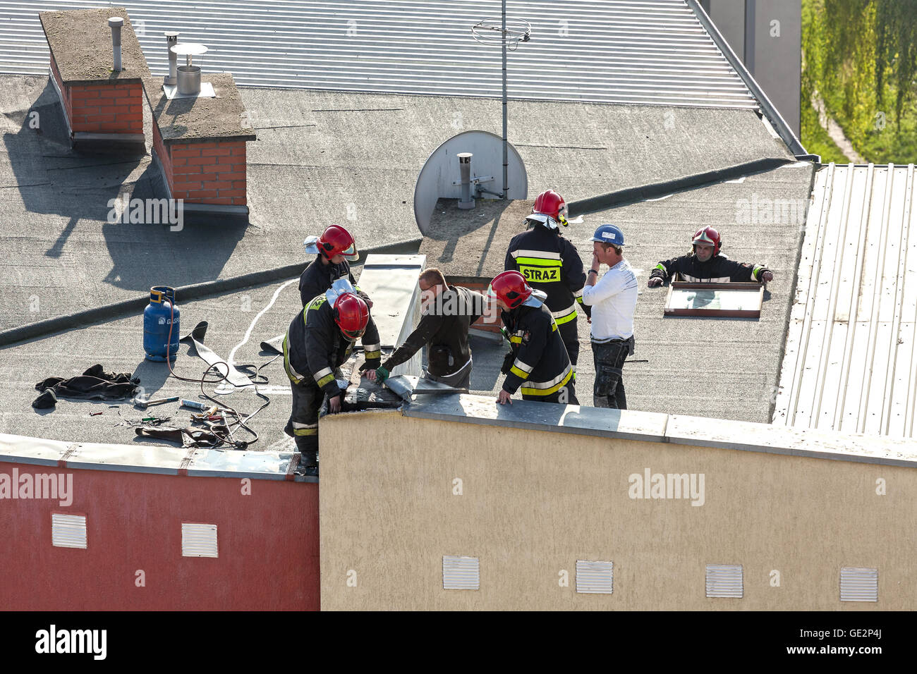Contrôle de pompiers d'un système de chauffage cheminée sur le toit d'un appartement. Banque D'Images