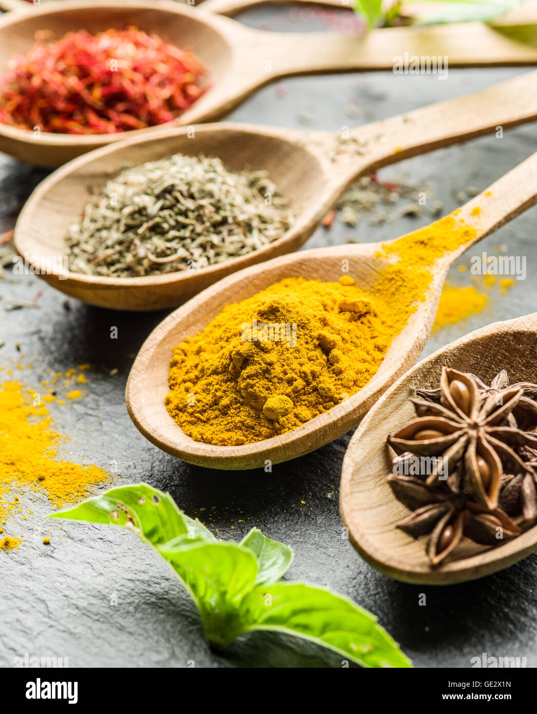 Assortiment d'épices colorées dans l'cuillères en bois. Banque D'Images