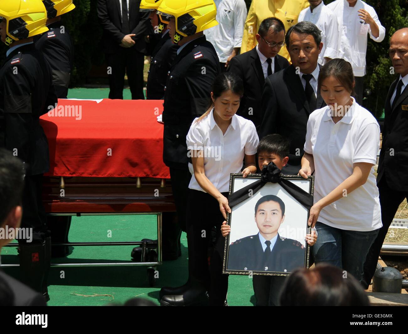 Hong Kong, Chine. 22 juillet, 2016. Fils de feu pompier Hui Chi-kit contient le portrait de son père au cours d'une cérémonie avec tous les honneurs pour lui à Hong Kong, Chine du sud, le 22 juillet 2016. Hong Kong Services Incendie du ministère a organisé les funérailles vendredi pour hui Chi-kit, 37 ans, qui a été tué dans un incendie mortel dans un bâtiment industriel dans l'Est de Kowloon. Credit : Wang Shen/Xinhua/Alamy Live News Banque D'Images