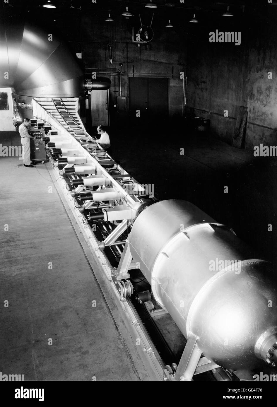 (1959) l'entrée atmosphérique simulateur à l'Ames Research Center de la NASA, Moffett Field, en Californie. Visible dans l'avant-plan, un grand réservoir contenant de l'air sous haute pression. Au sol directement derrière c'est une buse spéciale en forme de trompette, contured afin que l'air qui coule à travers elle change progressivement de la densité de la même manière que l'atmosphère de la terre les changements de densité avec l'altitude. Non visible sur cette photo est une arme à grande vitesse permet de lancer un modèle de test à terre re-vitesse d'entrée (17 000 mph) en amont par le biais d'une buse spéciale alors que l'air circule à travers elle. Les techniciens sont un Banque D'Images