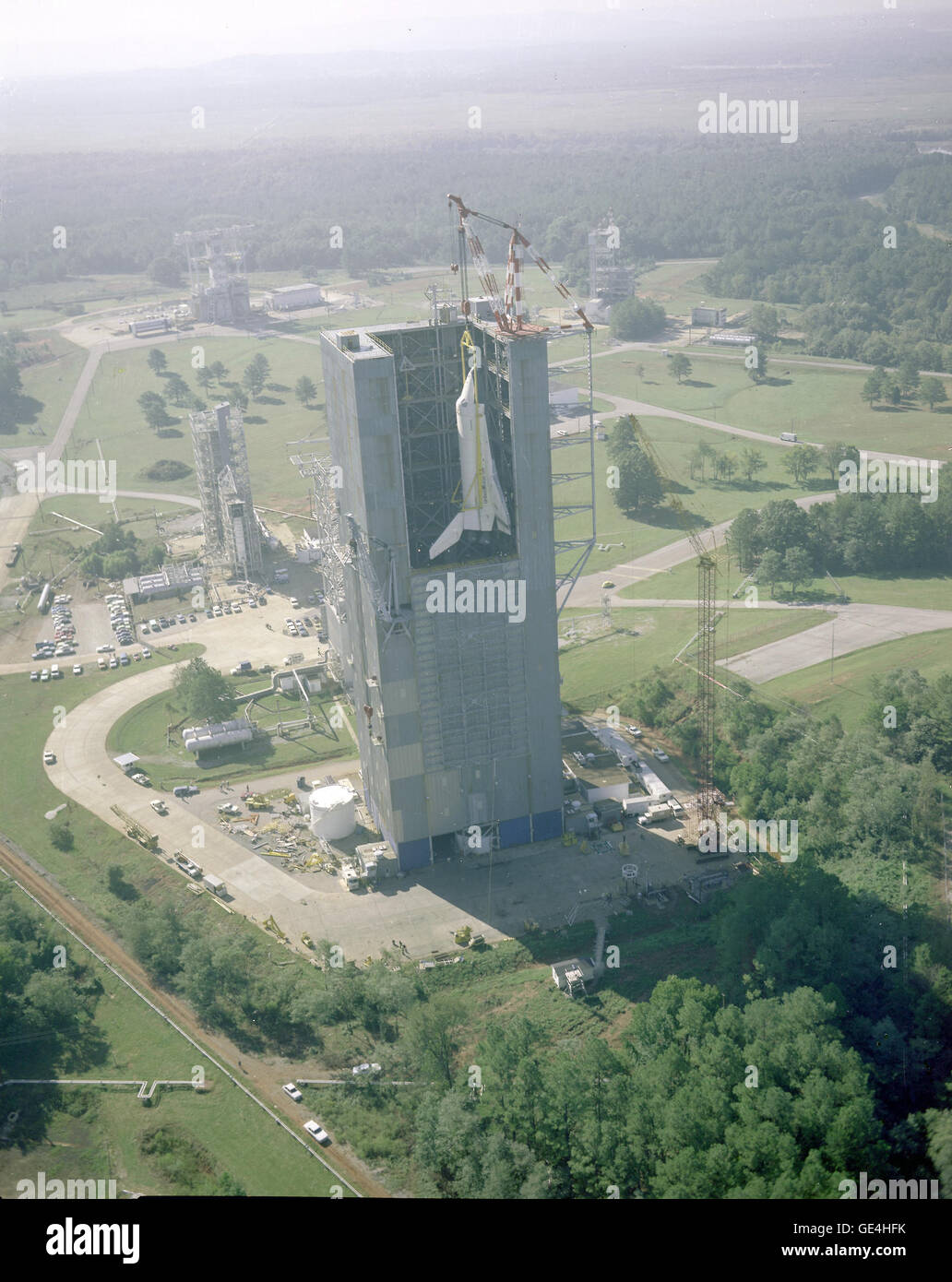 (4 octobre 1978) Vue aérienne de la navette spatiale Enterprise étant hissé dans Marshall's Stand d'essai dynamique pour l'essai de vibration au sol Vertical accouplées (MVGVT). L'essai a marqué la première fois que l'ensemble des éléments de la navette spatiale, un orbiteur, un réservoir externe (ET), et deux propulseurs (SRB), ont été accouplés ensemble. Le but de la vibration était de vérifier que la navette spatiale a procédé à la configuration de lancement comme prévu. Image # : 7992403 Banque D'Images