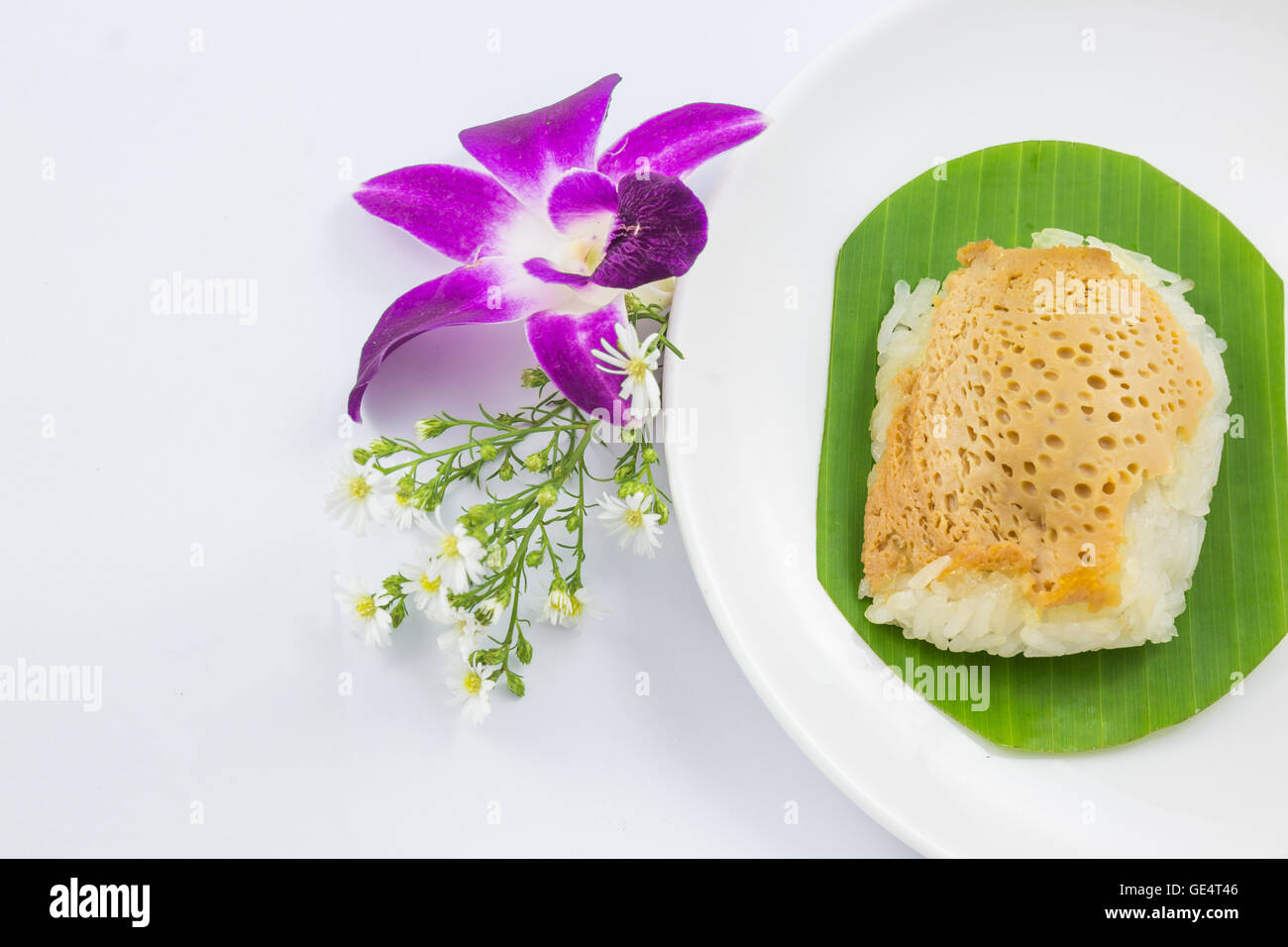 Le riz gluant cuit à la vapeur avec de la crème anglaise sur des feuilles de bananier et plat d'orchidée, fleur, riz collant, sucré dessert sucré thaïlandais, original Banque D'Images