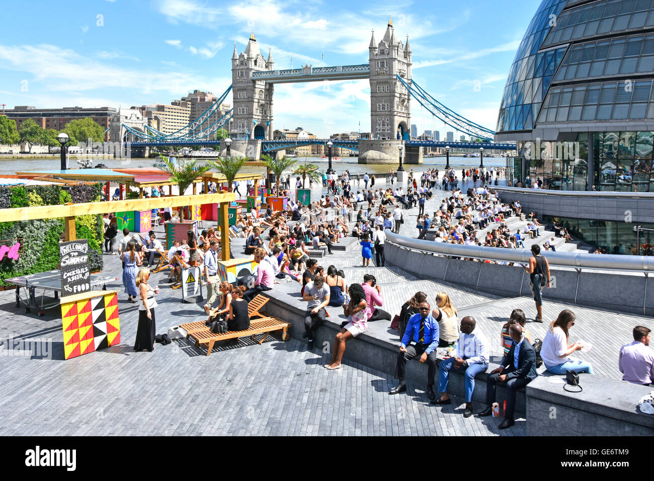 Les employés de bureau et les touristes de la journée se font une boisson estivale dans les stands de restauration autour de Scoop à More London City Hall & Tower Bridge sur la Tamise Southwark Royaume-Uni Banque D'Images