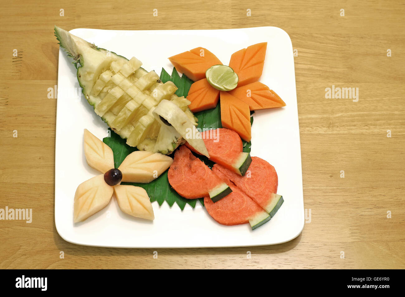 Mélange de fruits ananas papaye pastèque Melon et raisin on white plate Banque D'Images