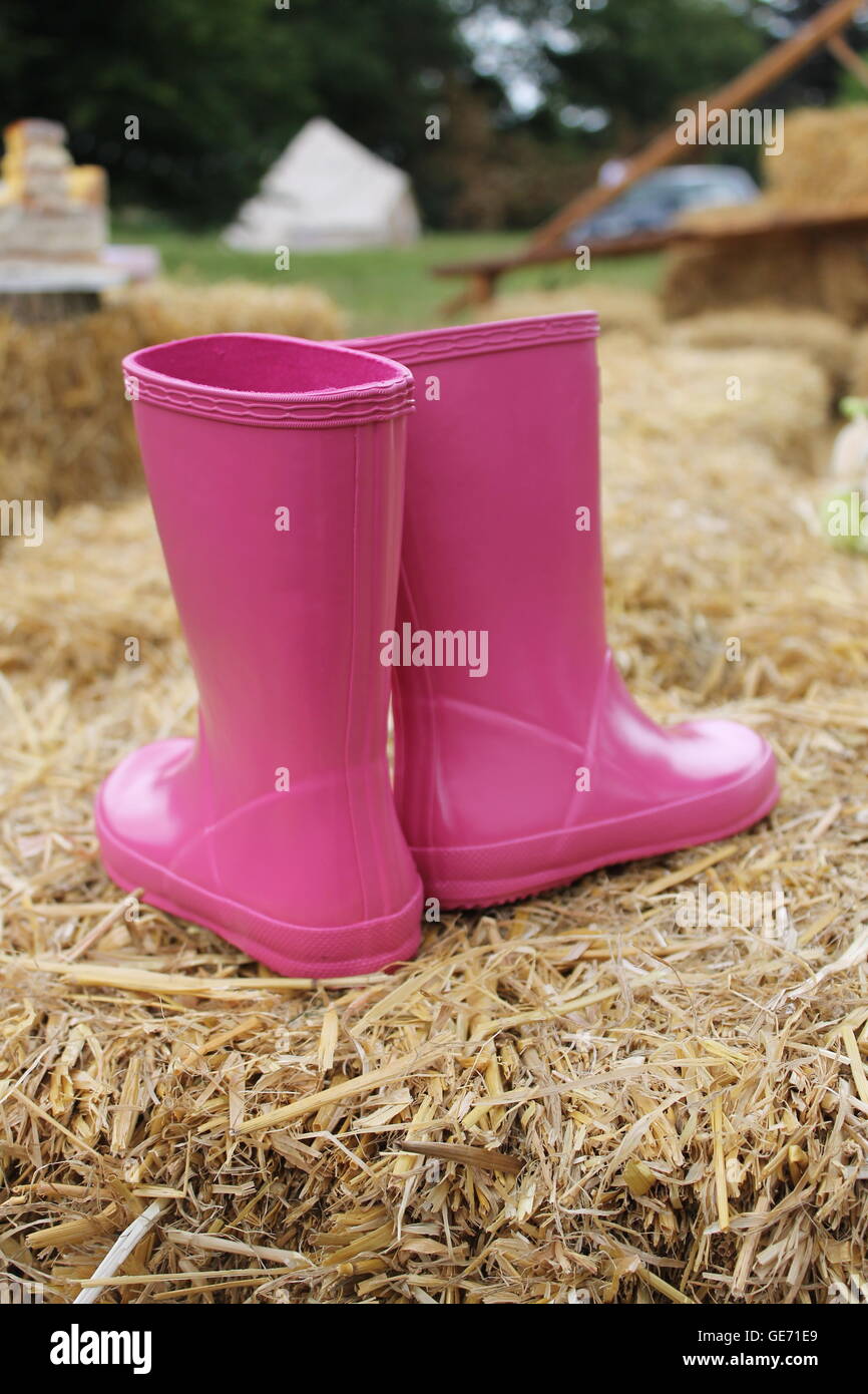 Wellies roses, girl's wellies, girl's shoes, chaussures roses, camping, festival, bottes, imperméables, jour de pluie, les flaques, les conditions météorologiques humides Banque D'Images