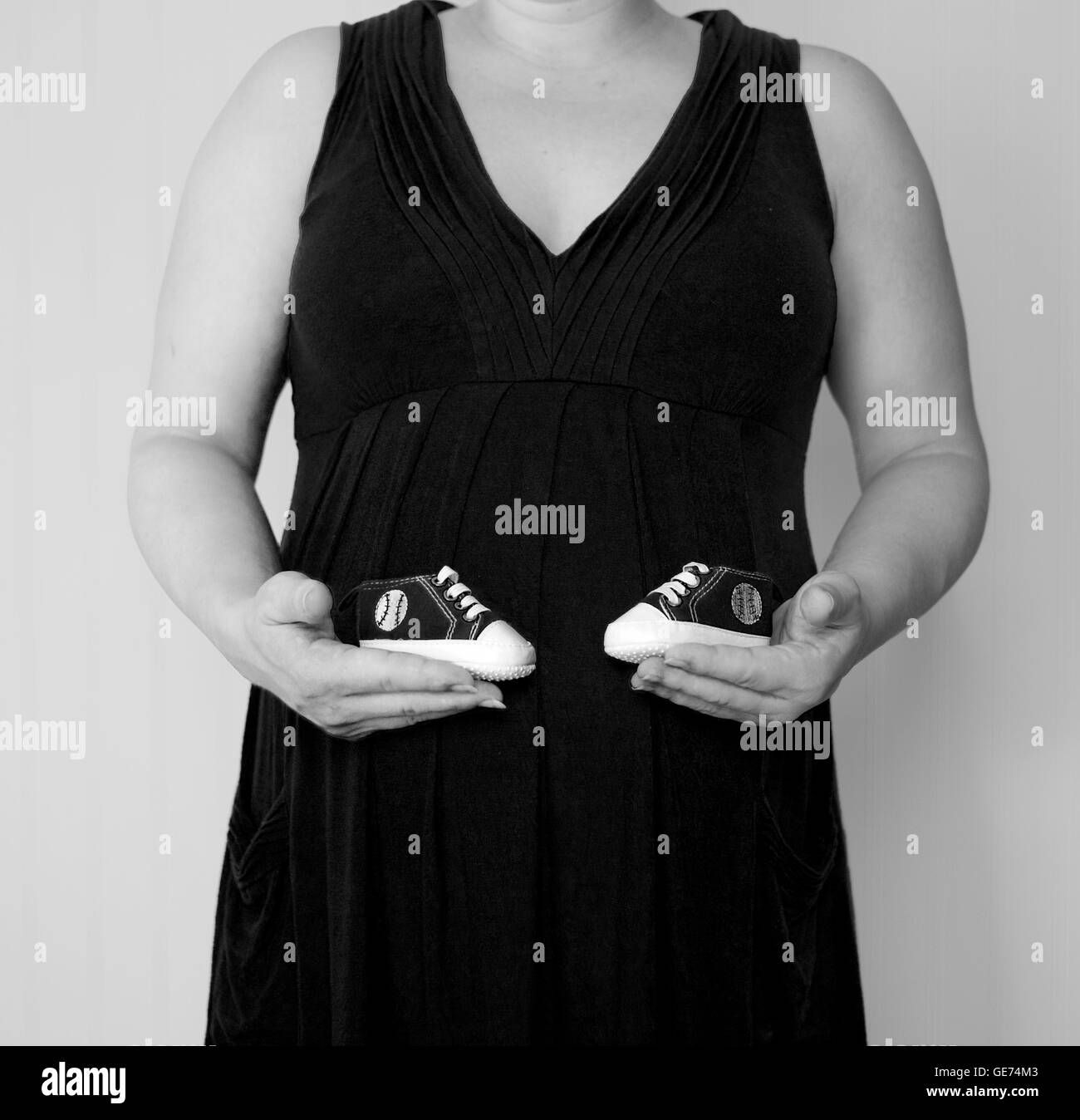 Pregnant woman holding shoes dans un studio photo Banque D'Images
