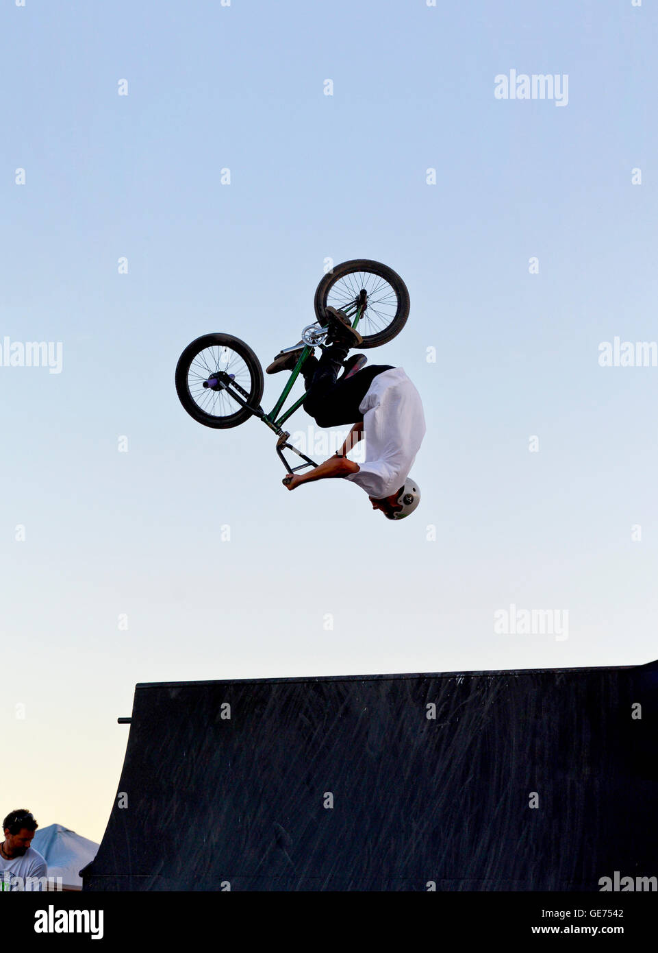 Une personne faisant un saut périlleux arrière sur un saut sur un vélo BMX Banque D'Images