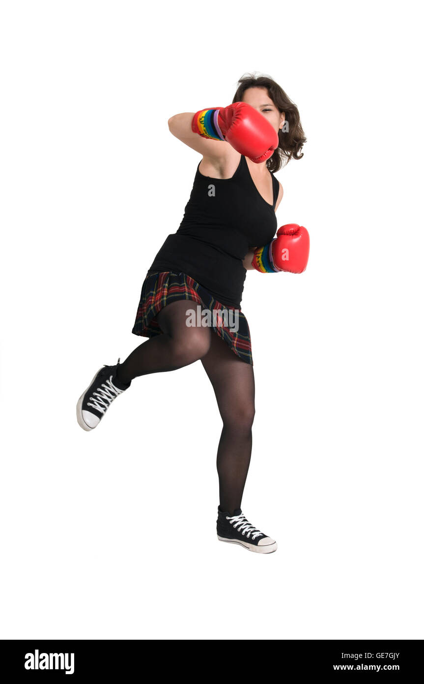 Jeune femme avec des gants de boxe lance un poinçon Banque D'Images