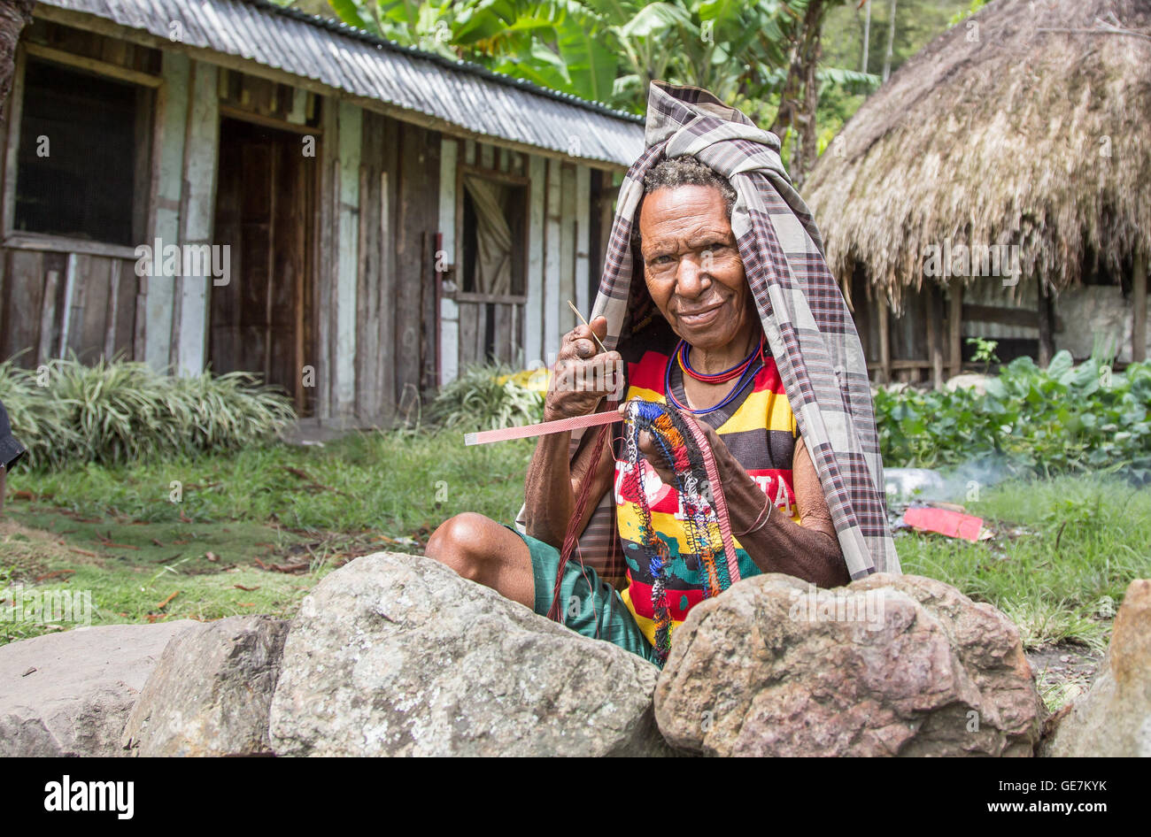 Baliem Valley, en Papouasie occidentale, Indonésie - 13 Février 2016 : une dame locale, manquant ses doigts, faisant un un sac shopping Banque D'Images