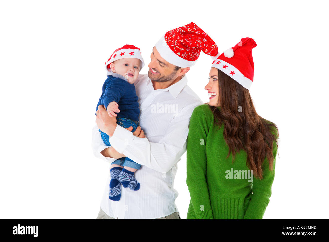 Une photo de heureux parents avec son fils. Famille de trois sont wearing Santa hats. Ils sont dans l'emploi temporaire isolated over white background. Banque D'Images