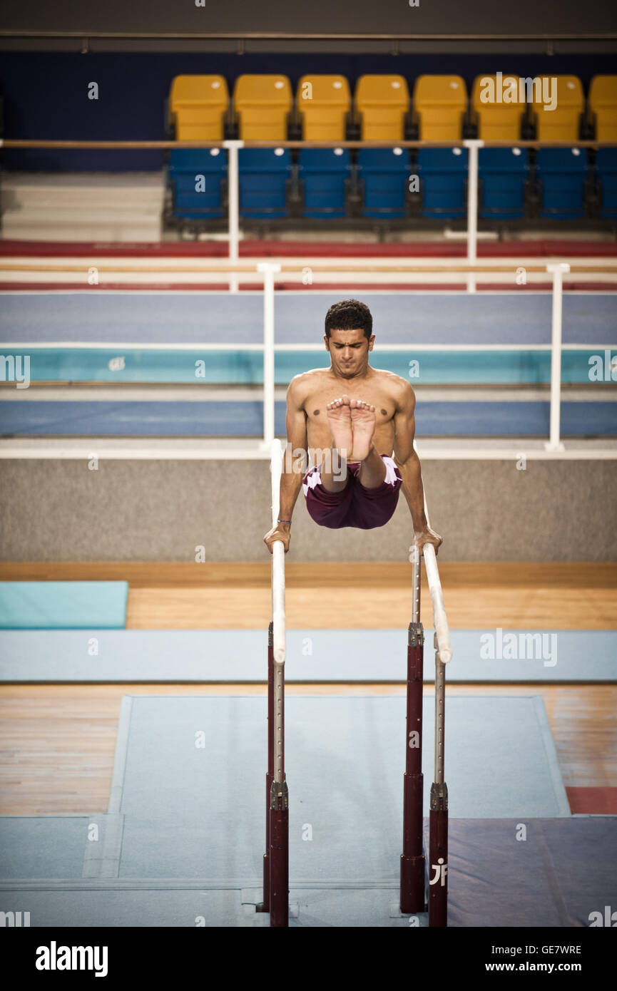 Les pratiques d'un gymnaste aux barres parallèles à l'Académie Aspire à l'excellence sportive à Doha, Qatar. Banque D'Images