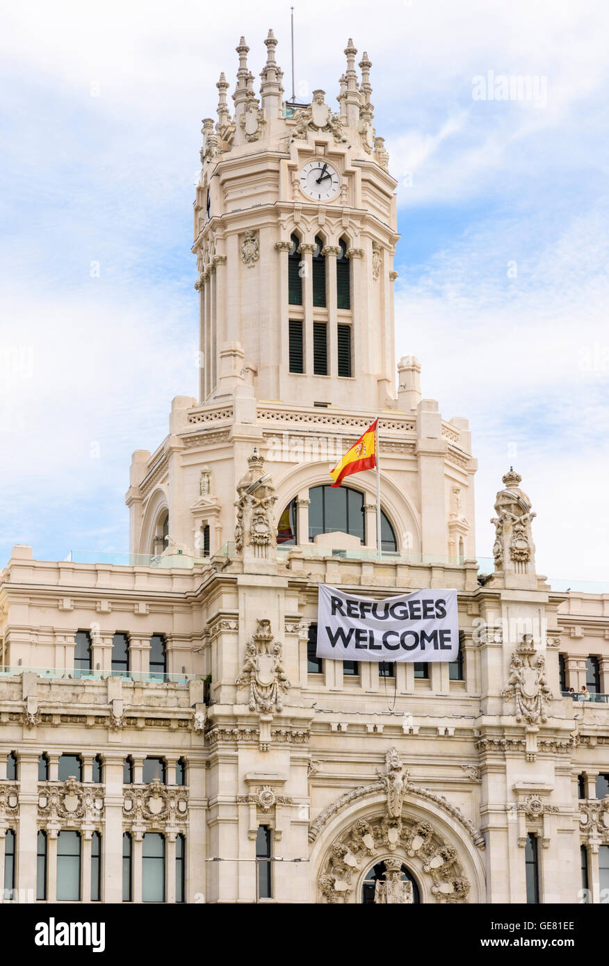 Les réfugiés à travers le drapé de l'affiche Bienvenue façade de l'hôtel Palacio de Cibeles, maintenant - Accueil de l'Hôtel de ville de Madrid, Madrid, Espagne Banque D'Images
