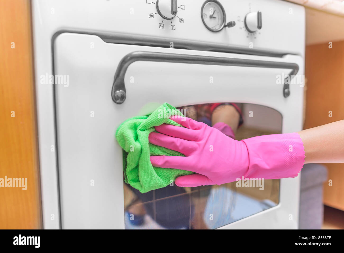 Les mains dans les gants lavé four extérieur. Le nettoyage de la cuisine. Banque D'Images