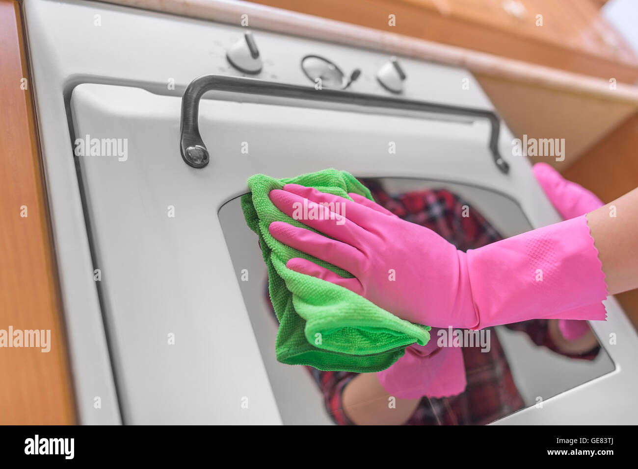 Les mains dans les gants lavé four extérieur. Le nettoyage de la cuisine. Banque D'Images