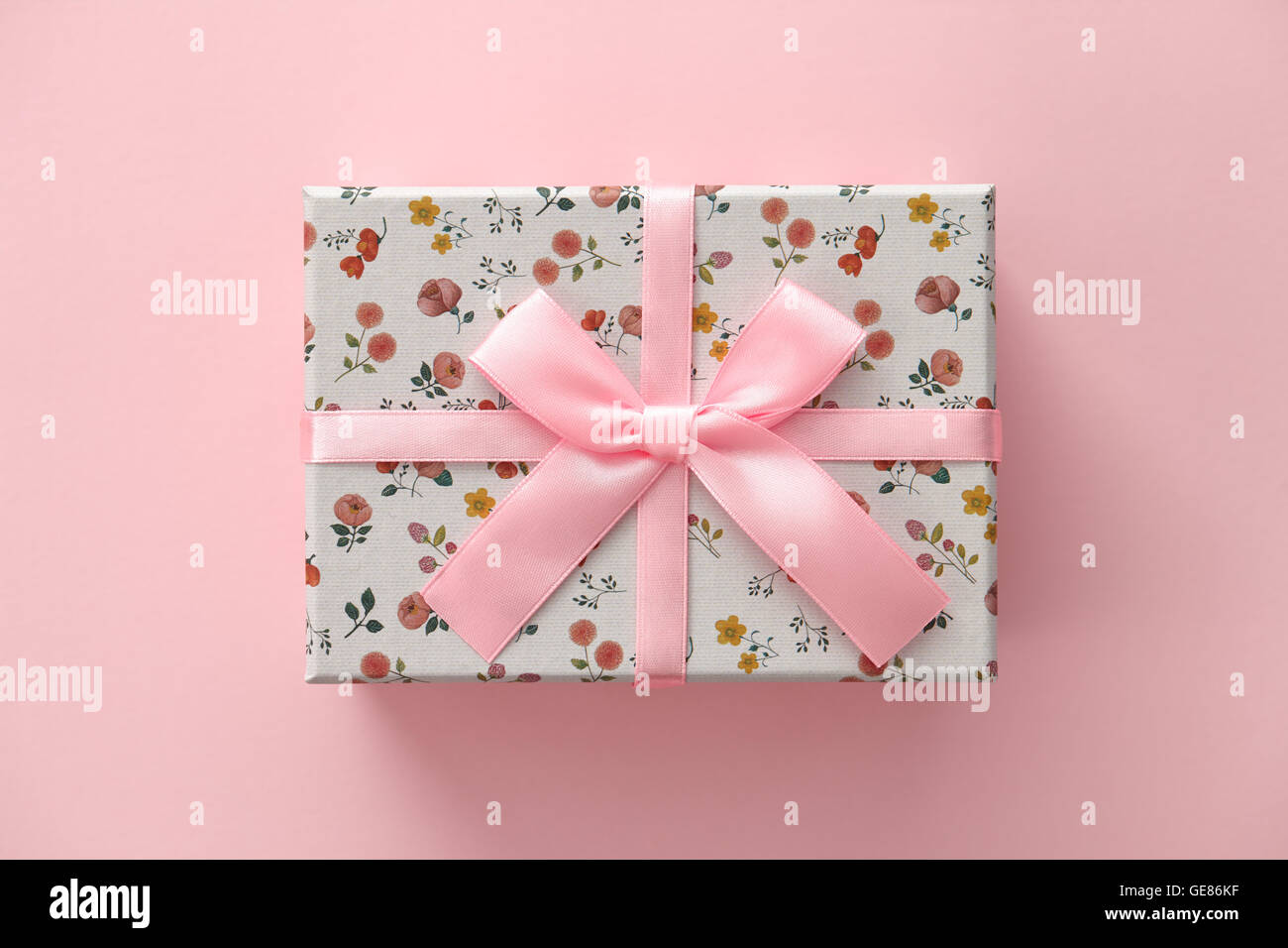Boîte cadeau motif floral sur fond rose Banque D'Images